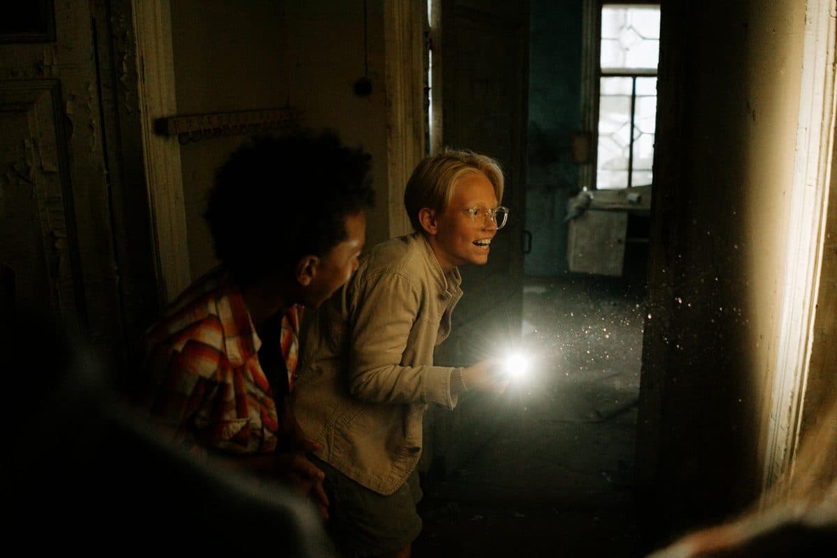 Investigators exploring a dark room with a flashlight