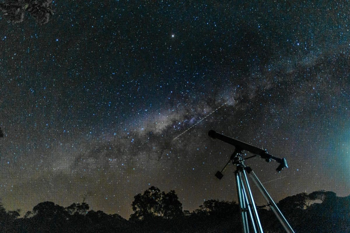 Telescope under a starry night sky with the Milky Way